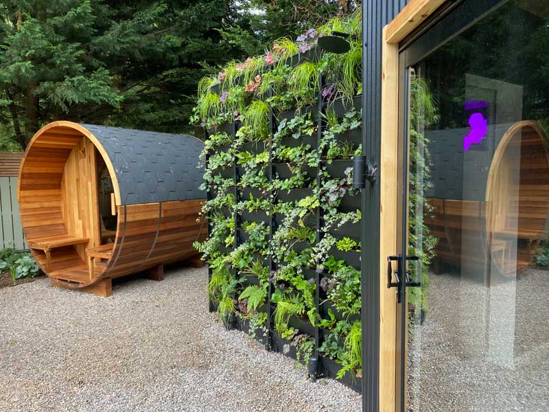 barrel shaped garden room beside a plantbox living green wall