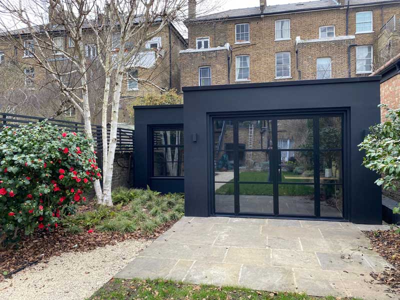 black and glass contemporary style garden office  in an overlooked urban garden