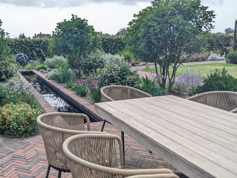 An outdoor dining view with a spectacular view over the garden. Design by DAVID LOY