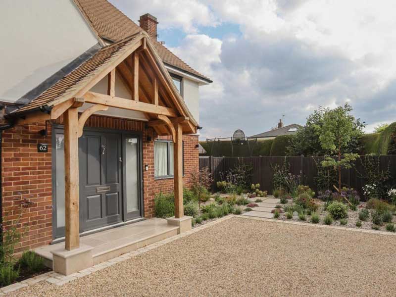 gravelled driveway with front door to the left of the picture and looking towards a lovely dry garden with limestone stepping stones leading to side gate