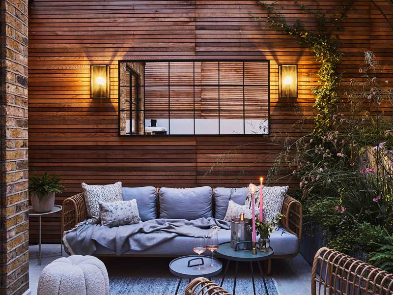 beautiful outdoor seating area with cedar clad walls and comfy sofas