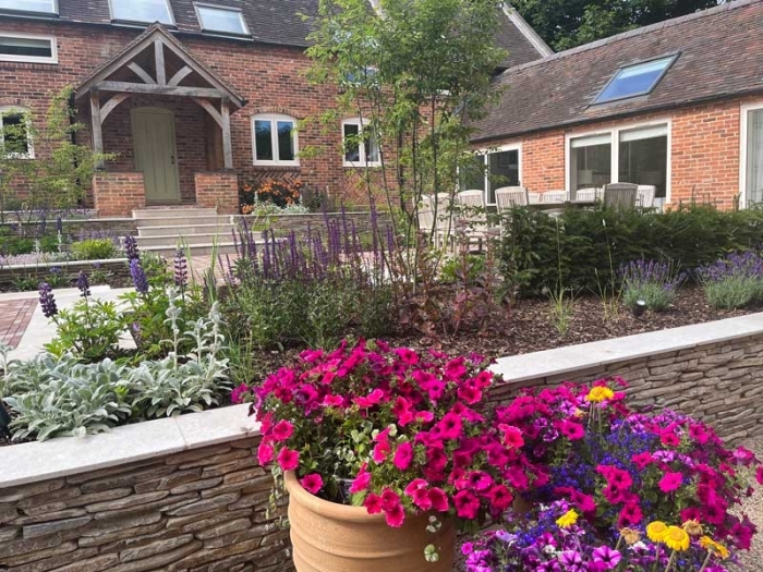 Front garden for a converted farm house in Derbyshire with vibrant planting and paddlestone retaining walls